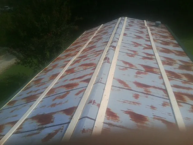 Rusted metal roof panels with new wood purlins before replacement — Storm Damage Roof Repair in Bell by Roofing Brothers