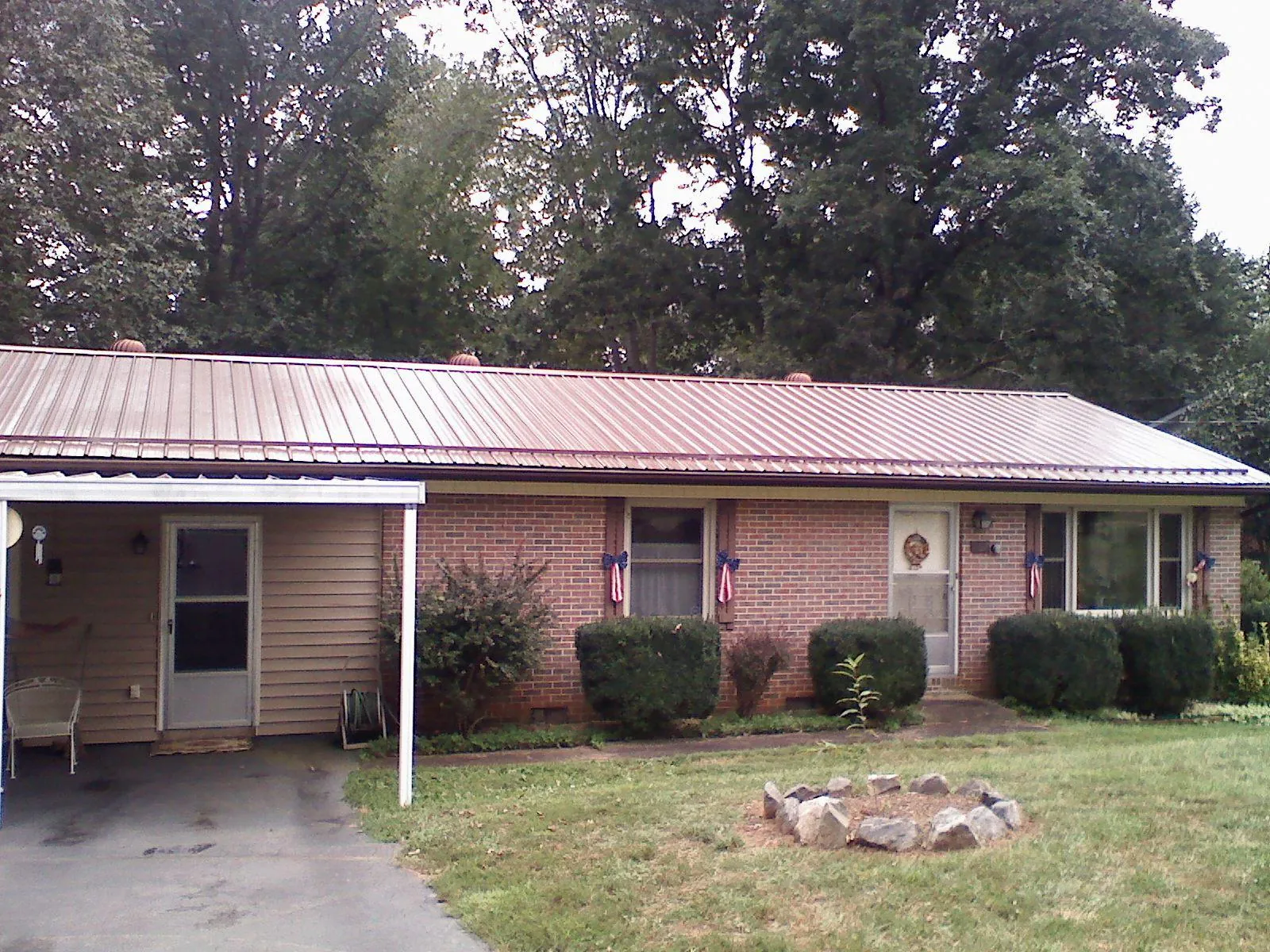 Bronze metal roof and carport on a brick ranch home — Roof Repair work by our crew in Bell